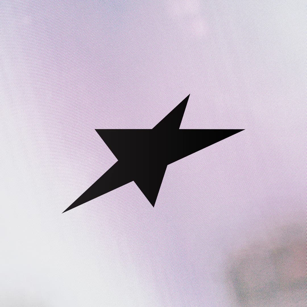 Black angular star on a pale purple background